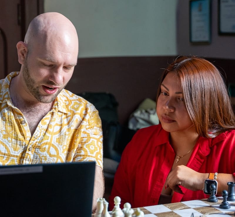 man and woman talking and working on laptop